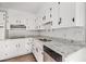 A well-lit kitchen featuring white cabinets, granite countertops, and stainless steel appliances at 7935 Sweetwater Dr, Douglasville, GA 30135