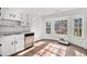 Bright kitchen featuring white cabinets, stainless steel dishwasher, and a charming bay window at 7935 Sweetwater Dr, Douglasville, GA 30135