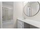 Bright bathroom featuring a shower-tub combination and a modern round mirror at 1214 Lake Pointe Cir, Roswell, GA 30075