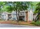 Attractive condo building with beige siding, stone accents, balconies, and lush landscaping at 1214 Lake Pointe Cir, Roswell, GA 30075