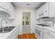 Functional kitchen with white cabinets and hardwood floors, open to a sunroom for natural light and space at 1214 Lake Pointe Cir, Roswell, GA 30075