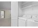 Convenient laundry area with appliances and shelving, designed for efficient organization and ease of use at 1214 Lake Pointe Cir, Roswell, GA 30075