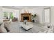 Cozy living room featuring a stone fireplace, complemented by abundant natural light from the surrounding windows at 1214 Lake Pointe Cir, Roswell, GA 30075