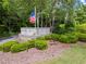 Community sign for Roswell Pointe featuring an American flag and well-maintained landscaping at 1214 Lake Pointe Cir, Roswell, GA 30075