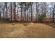 Expansive backyard with mature trees and fire pit, perfect for outdoor relaxation at 233 Yorkshire Ln, Villa Rica, GA 30180