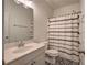 Cozy bathroom featuring a vanity sink, decorative tile floor, and a shower with a patterned curtain at 233 Yorkshire Ln, Villa Rica, GA 30180
