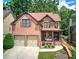 Charming two-story home with a brick and stone facade, a two-car garage, and a cozy front porch at 233 Yorkshire Ln, Villa Rica, GA 30180