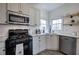 Well-lit kitchen features white cabinetry, stainless steel appliances, and modern subway tile backsplash at 233 Yorkshire Ln, Villa Rica, GA 30180