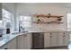 Bright kitchen boasting granite countertops, stainless steel dishwasher, and stylish floating wooden shelves at 233 Yorkshire Ln, Villa Rica, GA 30180