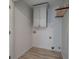 Laundry room with hardwood floors and storage cabinet to maximize space at 233 Yorkshire Ln, Villa Rica, GA 30180