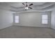 Spacious bedroom with a tray ceiling, a ceiling fan, and carpet, illuminated by natural light at 233 Yorkshire Ln, Villa Rica, GA 30180