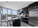 Modern kitchen boasts stainless steel appliances, island seating, and expansive windows offering city views at 3325 Piedmont Ne Rd # 3005, Atlanta, GA 30305