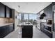 Contemporary kitchen featuring dark cabinetry, an island with seating, and large windows showcasing the city skyline at 3325 Piedmont Ne Rd # 3005, Atlanta, GA 30305