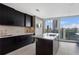 This gourmet kitchen has dark cabinets, a center island, and a large window with stunning cityscape views at 3325 Piedmont Ne Rd # 3005, Atlanta, GA 30305