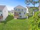 Expansive backyard with lush green lawn and view of the two-story home and wooden deck at 411 Riverclub Rd, Acworth, GA 30101
