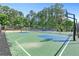A full view of the community basketball court and adjacent tennis court with a lush green tree line at 411 Riverclub Rd, Acworth, GA 30101