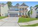 Charming two-story home featuring a covered porch, balcony, well-maintained lawn, and attached two-car garage at 411 Riverclub Rd, Acworth, GA 30101