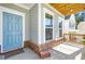 Inviting front porch featuring a blue front door, brick accents, and a 'home' welcome mat at 411 Riverclub Rd, Acworth, GA 30101