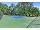 A full view of the community tennis courts with a lush green tree line in the background at 411 Riverclub Rd, Acworth, GA 30101