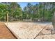 A full view of the community sand volleyball court with lush trees lining the perimeter at 411 Riverclub Rd, Acworth, GA 30101