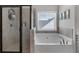 Elegant bathroom with a glass enclosed shower and a soaking tub beside a window at 4575 Birch Way, Loganville, GA 30052