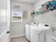 Well-lit laundry room featuring side-by-side washer and dryer units and shelving at 4575 Birch Way, Loganville, GA 30052