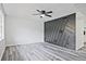 Open living room featuring hardwood floors, ceiling fan, gray accent wall, and lots of natural light at 4701 Flat Shoals Rd # 35E, Union City, GA 30291