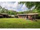 Large backyard with mature trees, colorful chairs, and a wooden exterior at 522 Knollwood Dr, Stockbridge, GA 30281