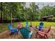 Outdoor fire pit area with colorful Adirondack chairs and string lights, perfect for entertaining at 522 Knollwood Dr, Stockbridge, GA 30281