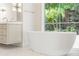 Bright bathroom featuring a soaking tub with view to the backyard at 2515 Habersham Rd, Atlanta, GA 30305