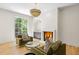 Cozy living room with fireplace, stylish light fixture, wet bar and a sun-drenched window at 2515 Habersham Rd, Atlanta, GA 30305
