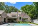 Stunning backyard pool with lush greenery and elegant brick home in the background at 2515 Habersham Rd, Atlanta, GA 30305