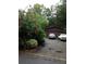 Home with a two-car garage, surrounded by lush trees and a well-maintained driveway at 3315 Canterbury Trl, Rex, GA 30273