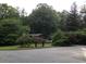 Home nestled amongst mature trees with flowering shrubs in the front yard at 3315 Canterbury Trl, Rex, GA 30273