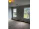 Standard bedroom featuring neutral gray walls, two bright windows, and plush carpeted floors at 500 Kings Pl, Riverdale, GA 30296