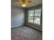 Another bedroom featuring neutral gray walls, a bright window, and plush carpeted floors at 500 Kings Pl, Riverdale, GA 30296