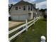Back exterior view of home with two-car garage, chimney, and a white picket fence surrounding the property at 500 Kings Pl, Riverdale, GA 30296