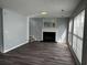 Living room with wood burning fireplace, luxury vinyl plank flooring, and many windows at 500 Kings Pl, Riverdale, GA 30296