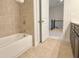 Tiled bathroom with a white tub and shower combo at 614 Harrington Hls, Decatur, GA 30032