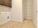 Tiled laundry room with upper cabinets, utility connections, and wire shelving at 614 Harrington Hls, Decatur, GA 30032