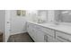Bright bathroom features a double sink vanity with white cabinets and dark wood flooring at 1098 Caruso Dr, Buford, GA 30518
