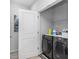 Laundry room with black washer and dryer, white walls, and storage shelves at 1098 Caruso Dr, Buford, GA 30518