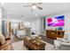 Open living room flows into the kitchen and features a TV, wooden floors and furnishings, and lots of natural light at 1098 Caruso Dr, Buford, GA 30518