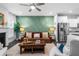 Inviting living room featuring a brown leather sofa, green accent wall, and a cozy rug at 1098 Caruso Dr, Buford, GA 30518