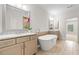 Bright bathroom featuring dual vanities, soaking tub, large mirrors, and neutral tile flooring at 1112 Cordia Nw Ave, Atlanta, GA 30318