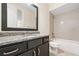 Bathroom features a granite countertop, dark wood cabinets, and a tiled shower over tub at 1112 Cordia Nw Ave, Atlanta, GA 30318