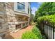 Serene side exterior featuring stone wall, bay window, and lush landscaping for enhanced privacy and appeal at 1112 Cordia Nw Ave, Atlanta, GA 30318