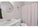 Bright bathroom with a modern round mirror, white vanity, and shower with a stylish curtain at 2735 Princeton Trce, Cumming, GA 30041