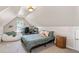 Cozy bedroom with sloped ceilings, a comfortable bed, and a workstation by the window at 2735 Princeton Trce, Cumming, GA 30041