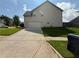 Rear view of home featuring an attached garage, spacious driveway, and well-maintained yard at 4316 Kershaw Dr, Snellville, GA 30039
